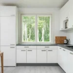 Elementmaja kööginurk valgete kappide, akna ja kaasaegse sisustusega
